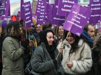 Demonstrators hold placards as they participate in a protest to condemn violence against women, organized by feminist organizations, in Pari...