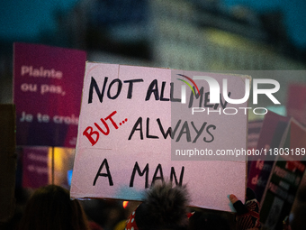 A demonstrator holds a placard reading ''not all men but always a man'' during a protest to condemn violence against women, called by femini...