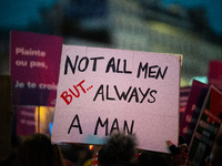 A demonstrator holds a placard reading ''not all men but always a man'' during a protest to condemn violence against women, called by femini...