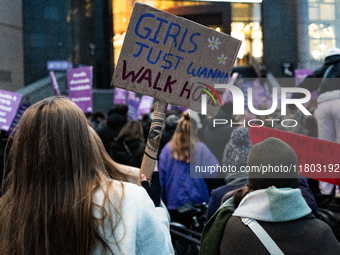 A demonstrator holds a placard reading ''girls just wanna go home'' during a protest to condemn violence against women, called by feminist o...