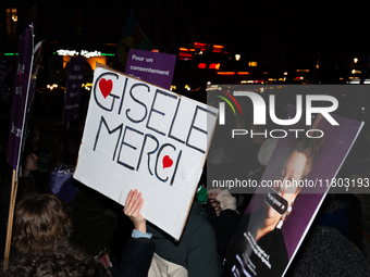 A demonstrator holds a placard reading ''Gisele Thank you'' during a protest to condemn violence against women, called by feminist organizat...