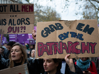 A demonstrator holds a placard reading ''grab them by the patriarchy'' during a protest to condemn violence against women, called by feminis...