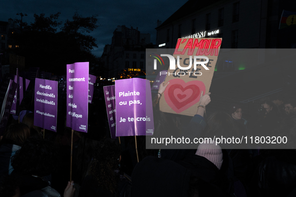 A demonstrator holds a placard reading ''love only hits the heart'' during a protest to condemn violence against women, called by feminist o...