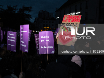 A demonstrator holds a placard reading ''love only hits the heart'' during a protest to condemn violence against women, called by feminist o...