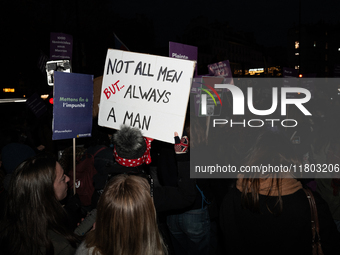 A demonstrator holds a placard reading ''not all men, but always a man'' during a protest to condemn violence against women, called by femin...