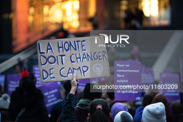 A demonstrator holds a placard reading ''shame must change sides'' during a protest to condemn violence against women, organized by feminist...