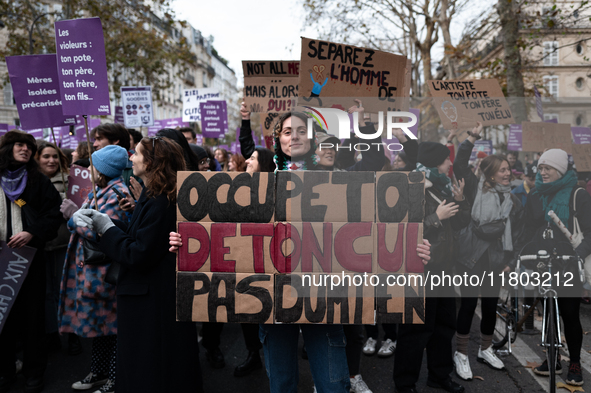 A demonstrator holds a placard reading ''take care of your ass, not mine'' during a protest to condemn violence against women, called by fem...