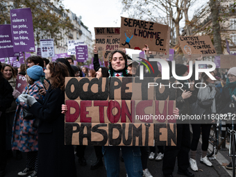 A demonstrator holds a placard reading ''take care of your ass, not mine'' during a protest to condemn violence against women, called by fem...