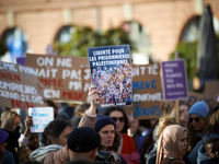 A protester holds a billboard reading 'Freedom for Palestinian women'. Women from the collective NousToutes and other organizations such as...