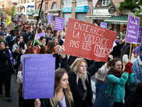 A woman holds a red placard reading 'Bury violence not women'. Women from the collective NousToutes and other organizations such as SUD or A...