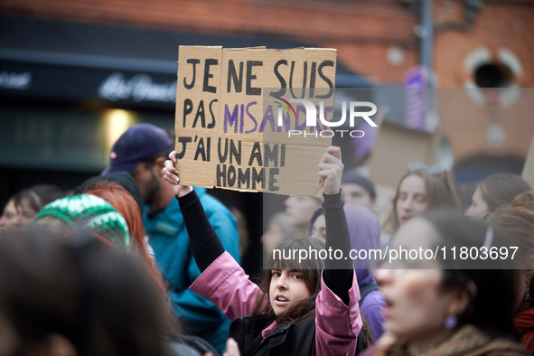 A young woman holds a cardboard sign that reads, 'I'm not a misandrist, I have a male friend'. Women from the collective NousToutes and othe...