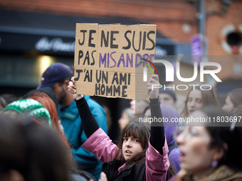 A young woman holds a cardboard sign that reads, 'I'm not a misandrist, I have a male friend'. Women from the collective NousToutes and othe...