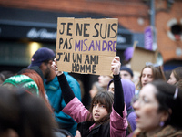 A young woman holds a cardboard sign that reads, 'I'm not a misandrist, I have a male friend'. Women from the collective NousToutes and othe...