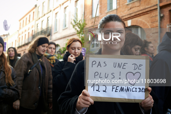 A young woman holds a cardboard sign reading 'Not one more! 122 feminicides'. Women from the collective NousToutes and other organizations s...