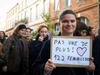 A young woman holds a cardboard sign reading 'Not one more! 122 feminicides'. Women from the collective NousToutes and other organizations s...