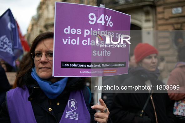 A woman holds a placard reading '94% of complaints for rape are dropped'. Women from the collective NousToutes and other organizations such...