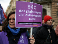 A woman holds a placard reading '94% of complaints for rape are dropped'. Women from the collective NousToutes and other organizations such...