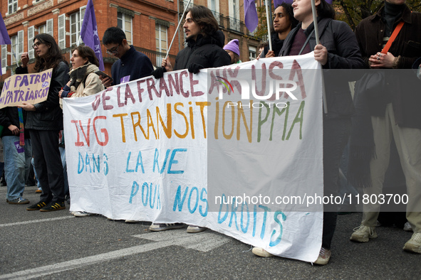 People hold a sheet reading 'From France to USA, Abortion, transition and ART, in the streets for our rights'. Women from the collective Nou...