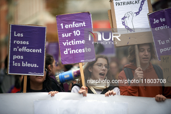 People hold placards reading 'Roses don't wipe away bruises' and 'One child in 10 is a victim of incest'. Women from the collective NousTout...