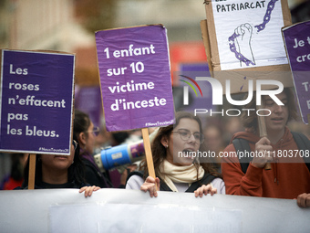 People hold placards reading 'Roses don't wipe away bruises' and 'One child in 10 is a victim of incest'. Women from the collective NousTout...