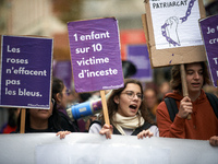 People hold placards reading 'Roses don't wipe away bruises' and 'One child in 10 is a victim of incest'. Women from the collective NousTout...