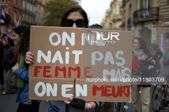 A woman holds a placard reading 'One isn't born a woman but one will die from it'. Women from the collective NousToutes and other organizati...