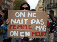 A woman holds a placard reading 'One isn't born a woman but one will die from it'. Women from the collective NousToutes and other organizati...