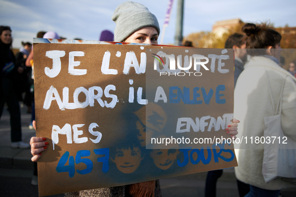 A woman holds a cardboard sign reading 'I quit him and he took my three children 457 days'. Women from the collective NousToutes and other o...