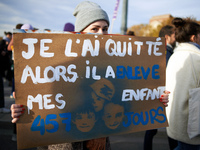 A woman holds a cardboard sign reading 'I quit him and he took my three children 457 days'. Women from the collective NousToutes and other o...