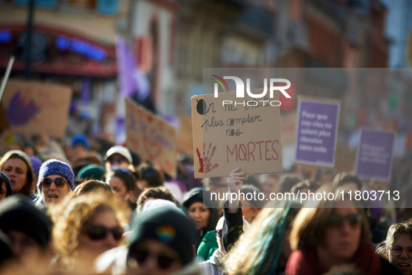 A woman holds a placard reading 'We don't want anymore to continue to count our dead'. Women from the collective NousToutes and other organi...