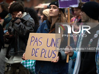 A woman holds a placard reading 'Not one more'. Women from the collective NousToutes and other organizations such as SUD and Amnesty Interna...