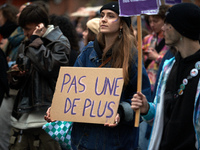 A woman holds a placard reading 'Not one more'. Women from the collective NousToutes and other organizations such as SUD and Amnesty Interna...