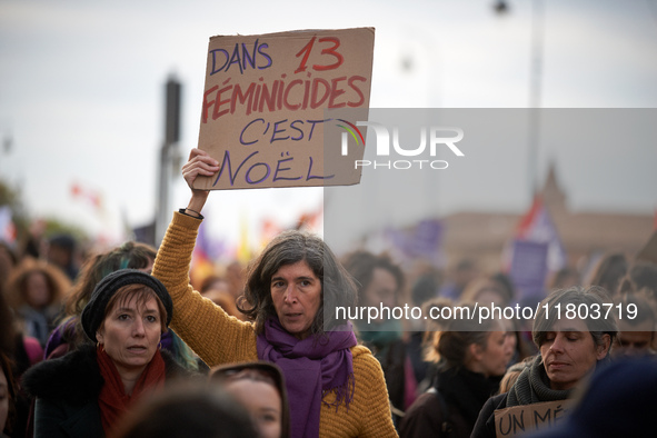 A woman displays a placard reading 'In 13 feminicides, it's Christmas'. Women from the collective NousToutes and other organizations such as...