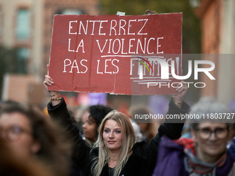 A woman holds a placard reading 'Bury violence not women'. Women from the collective NousToutes and other organizations such as SUD or Amnes...