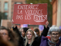 A woman holds a placard reading 'Bury violence not women'. Women from the collective NousToutes and other organizations such as SUD or Amnes...