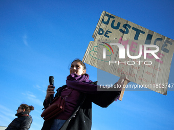 A woman holds a cardboard sign reading 'Shit justice, 94% of all complaints filed for rape are dropped'. Women from the collective NousToute...