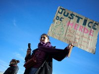 A woman holds a cardboard sign reading 'Shit justice, 94% of all complaints filed for rape are dropped'. Women from the collective NousToute...