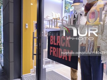 Promotional signage advertises up to 70% off for Black Friday at a clothing store in Bari, Italy, on November 24, 2024. The image highlights...