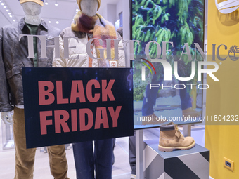 Promotional signage advertises up to 70% off for Black Friday at a clothing store in Bari, Italy, on November 24, 2024. The image highlights...