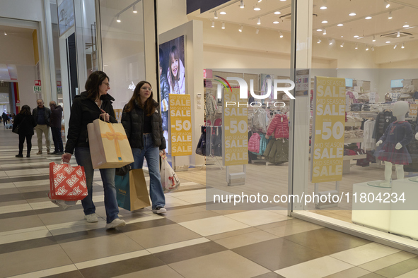 Promotional signage advertises up to 70% off for Black Friday at a clothing store in Foggia, Italy, on November 24, 2024. The image highligh...