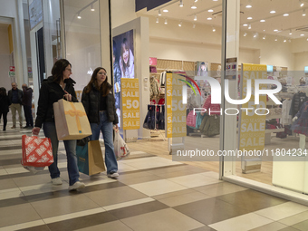 Promotional signage advertises up to 70% off for Black Friday at a clothing store in Foggia, Italy, on November 24, 2024. The image highligh...