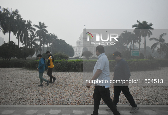 People walk inside a park on a foggy winter morning in Kolkata, India, on November 24, 2024. 