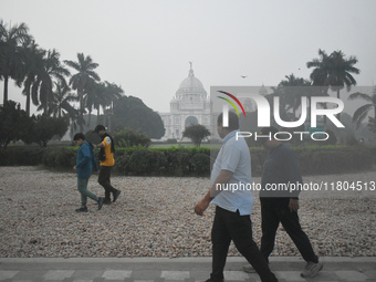 People walk inside a park on a foggy winter morning in Kolkata, India, on November 24, 2024. (