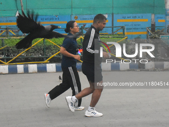 People run on the street in Kolkata, India, on November 24, 2024. (