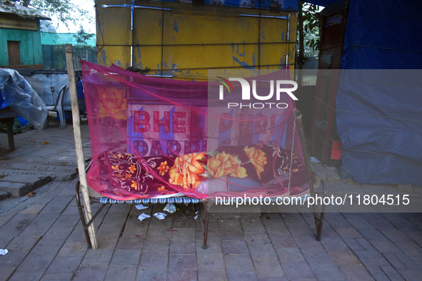 A person sleeps beside the street on a winter morning in Kolkata, India, on November 24, 2024. 