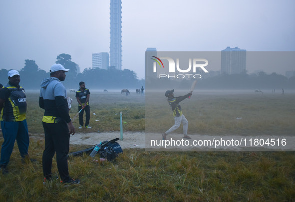 People play cricket inside a ground in Kolkata, India, on November 24, 2024. 