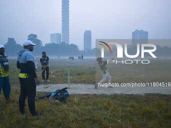 People play cricket inside a ground in Kolkata, India, on November 24, 2024. (