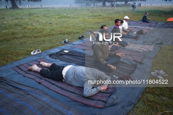 Old people perform yoga inside the ground on a foggy winter morning in Kolkata, India, on November 24, 2024. 