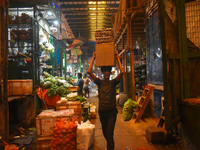 A boy carries eggs on his head while walking inside a wholesale market in Kolkata, India, on November 24, 2024. (