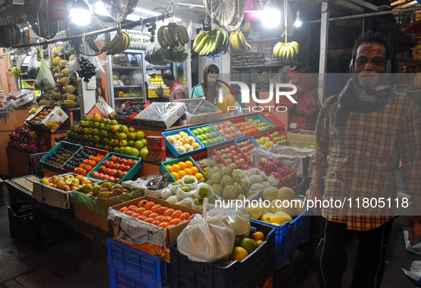 A person passes next to a fruit shop inside a wholesale market in Kolkata, India, on November 24, 2024. 